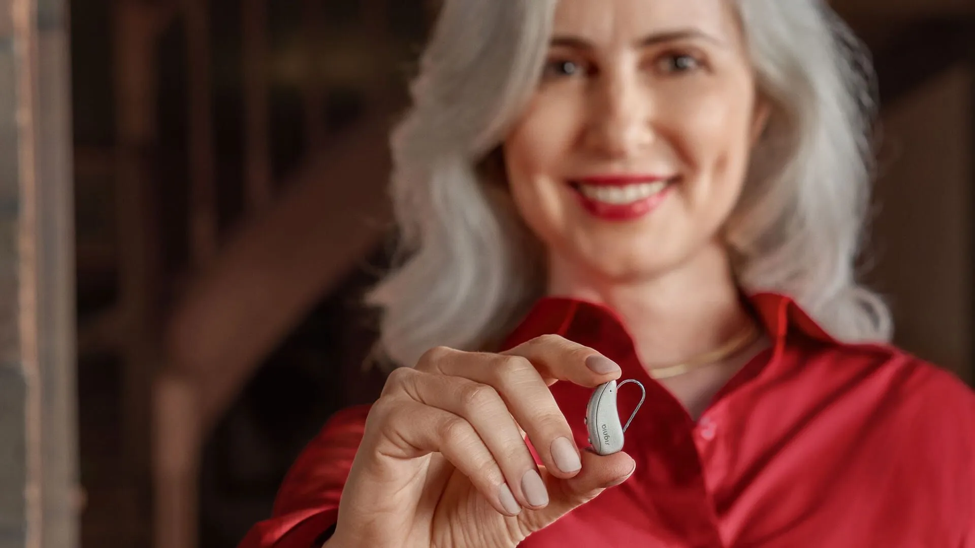 Woman holding a Signia Pure Charge&Go MaX hearing aid