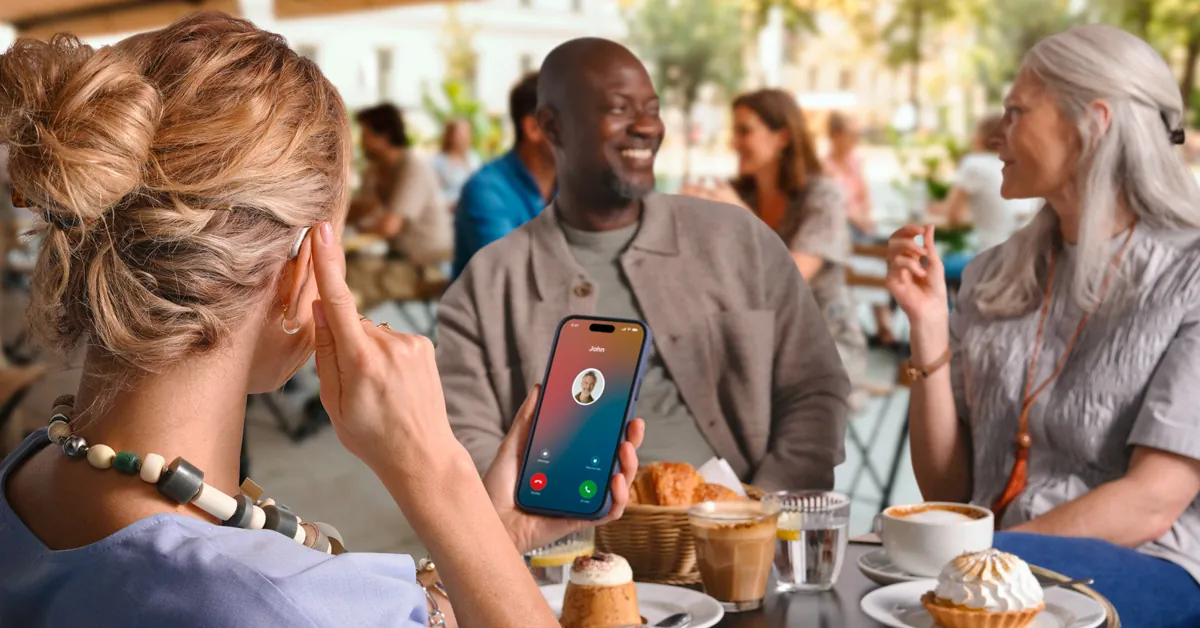 Woman taking a hands-free phone call through Oticon Reveal hearing aids
