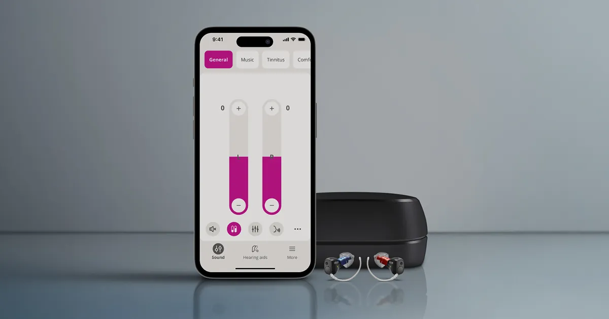 Oticon Companion app on a phone next to Oticon Zeal hearing aids and charger